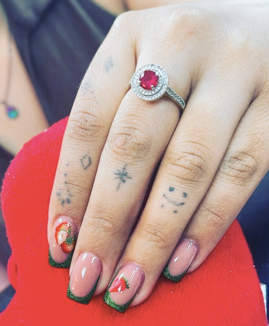 Green glitter French nails with strawberry art