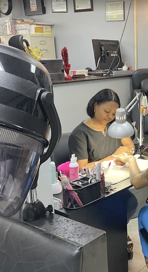 Nail technician working with a client at Luigy's Beauty Salon